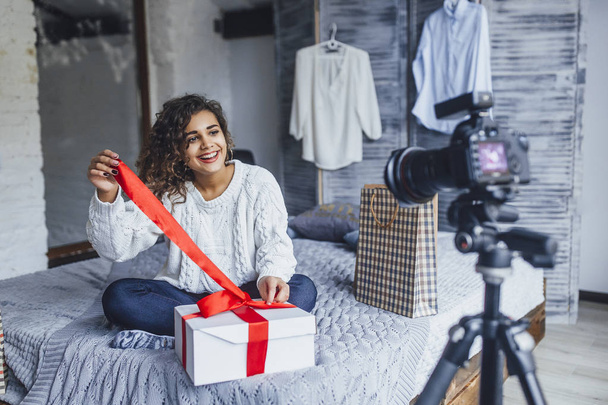 young beautiful blogger writing video for blog, unpacking her gift in loft style room - Fotoğraf, Görsel