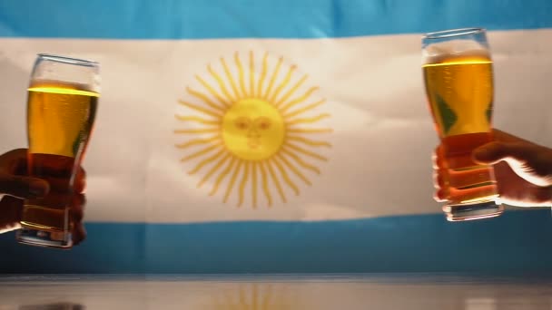 Fani brzęk szklanki piwa, argentyńskie flagi na tle, wsparcie zespołu sportowego - Materiał filmowy, wideo