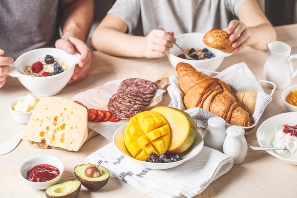 Family breakfast table with croissants, jam, ham, cheese,  butte - Fotó, kép