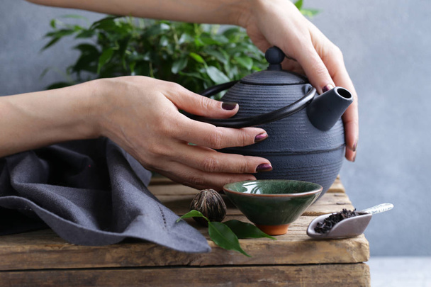 чугунный чайник на деревянном столе для чайной церемонии
 - Фото, изображение