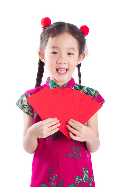Petite fille chinoise en couleur rouge stand de robe traditionnelle, tenant l'argent de paquet rouge
 - Photo, image