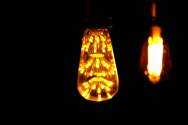 Класичний ретро розжарювання призвело до електричної лампи на чорному фоні, старовинна лампа
 - Фото, зображення