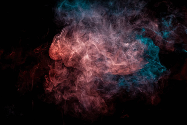 Espessa fumaça azul e vermelha colorida na forma de uma borboleta em um fundo isolado preto. Antecedentes da fumaça do vape. Mocap para t-shirt legal
 - Foto, Imagem