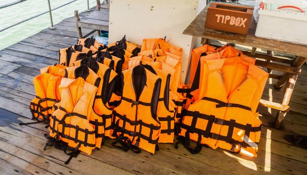Grupo de chaleco salvavidas en barco con caja de consejos
 - Foto, imagen