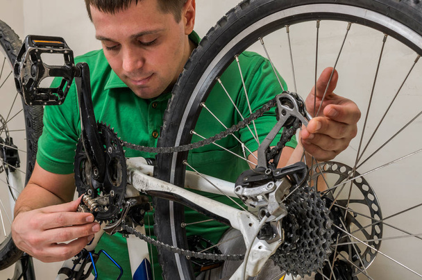 Master repairs bicycle in bicycle repair shop - Photo, Image