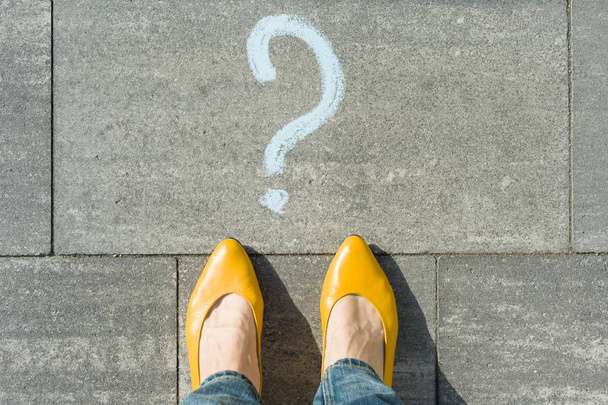 Woman feet with question mark in front of her legs painted on the asphalt - Photo, Image