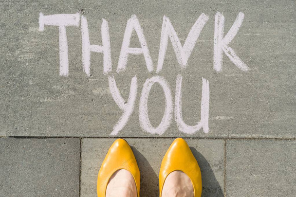 Female feet with text thank you written on grey sidewalk - Fotoğraf, Görsel
