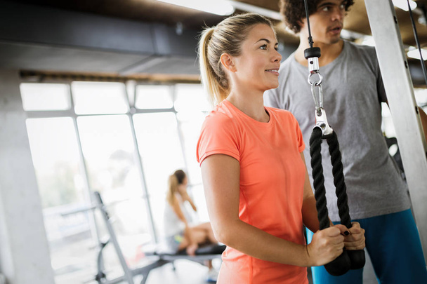 Personal trainer helping woman reach goals in gym - Zdjęcie, obraz