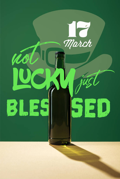 glass beer bottle with not lucky just blessed lettering on green background - Foto, Imagem