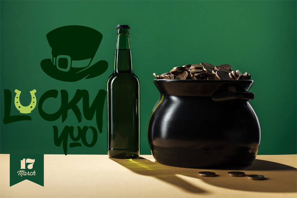 Bierflasche und schwarzer Topf mit Goldmünzen in der Nähe von lucky you Schriftzug auf grünem Hintergrund - Foto, Bild