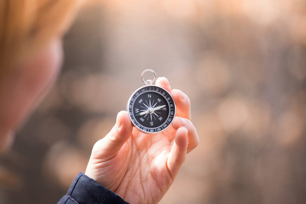 Compass holding in the hand of a girl, outdoor adventure, blurry - Foto, imagen