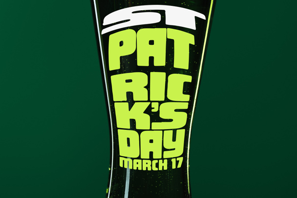 close up de copo de cerveja com st patrick dia lettering no fundo verde
 - Foto, Imagem