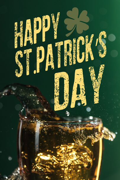 glass of beer with splash near happy st patricks day lettering on green background - Photo, Image