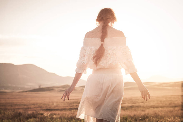 rothaarige Mädchen in einem Weizenfeld in einem weißen Kleid lächelt ein lo - Foto, Bild