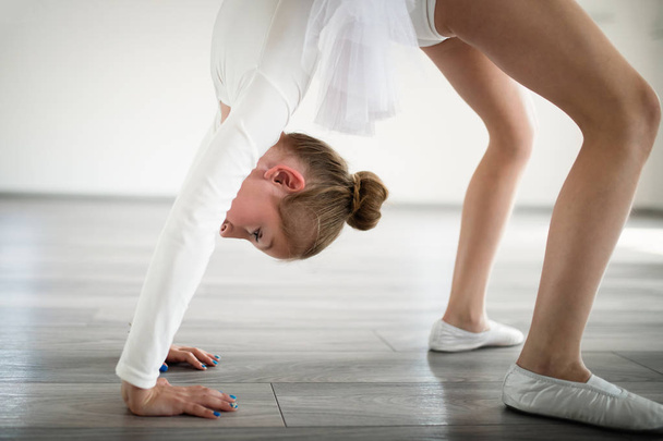 Young ballerina in tutu practicing dance moves. Young girl in ballet dress at dance school. - Fotografie, Obrázek