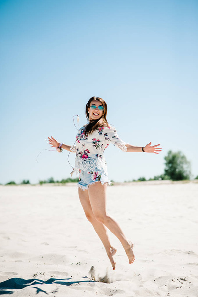 Happy Beautiful stylish sexy young girl having fun while jumping on sandy beach in nature, bachelorette party in boho style  - Photo, Image