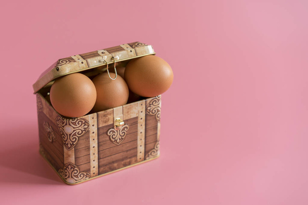 easter concept. eggs in a chest on a pink background. copy space. easter eggs in a treasure chest. copy space - Foto, Imagem