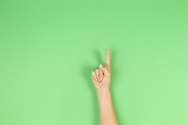 Kid hand showing one finger on green background - Foto, Imagem