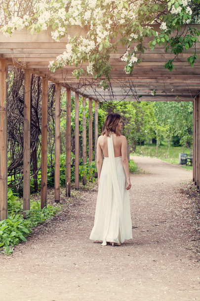 Femme parfaite en robe blanche dans le jardin fleuri en plein air
 - Photo, image