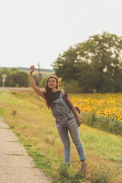 beautiful girl with  backpack hitchhiking. concept - travel, adventure, freedom. Copy space - Foto, Bild