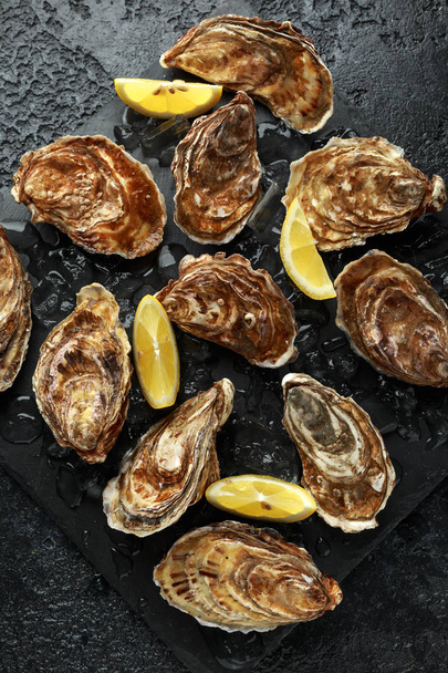 Fresh Oysters platter with lemon and ice. ready to open and eat - Photo, Image