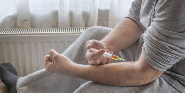 eine Person mit einer Nadel in einer Vene mit einem Medikament - Foto, Bild