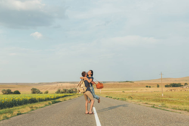 young guy circling the girl on the road. Lifestyle, romance, love, travel. Copy space - Foto, Bild