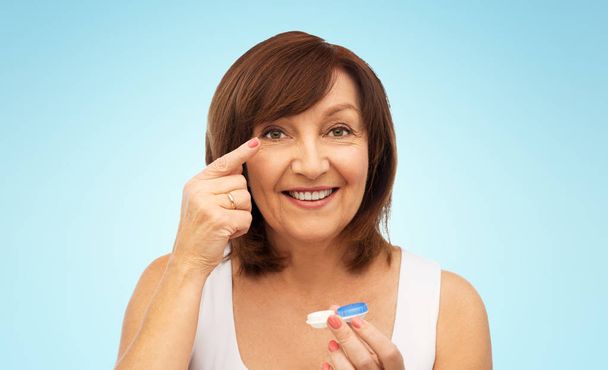 happy senior woman applying contact lenses - Foto, afbeelding