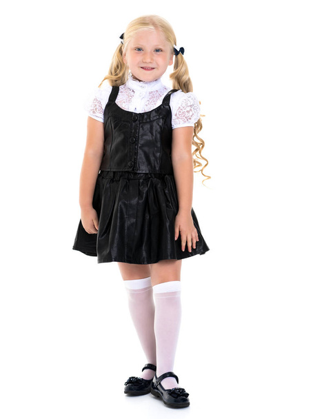 Beautiful little girl in a school uniform. - Фото, зображення