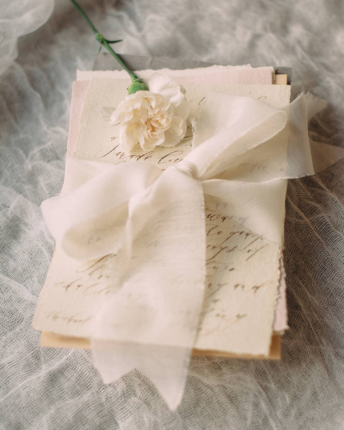Invitation card for the inscription with a beautiful summer flower. Romantic vintage letters with white clove flower and ivory ribbon - Photo, Image