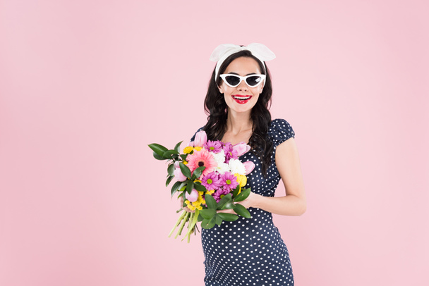 Charming pregnant woman in sunglasses holding flower bouquet isolated on pink - Photo, Image