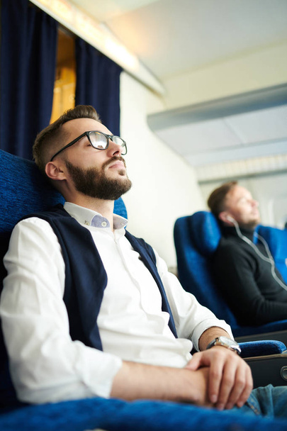 Modern uçağın rahat koltuğunda oturan birinci sınıf uçuş keyfini çıkarırken uyuyan yakışıklı sakallı adamın yan görünüm portresi, kopya alanı - Fotoğraf, Görsel
