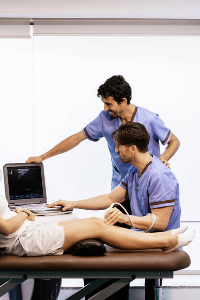 Physiotherapist giving knee therapy to a woman - Foto, Imagen