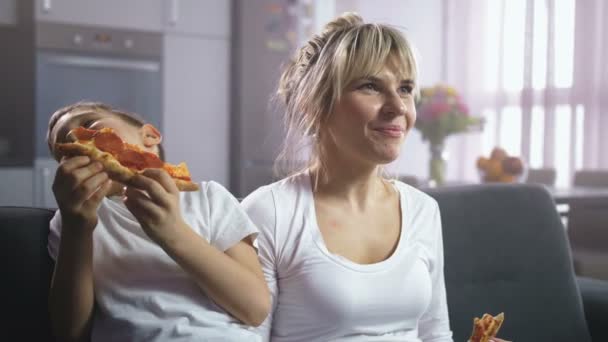 Familie lacht, isst Pizza und guckt Zeichentrick - Filmmaterial, Video