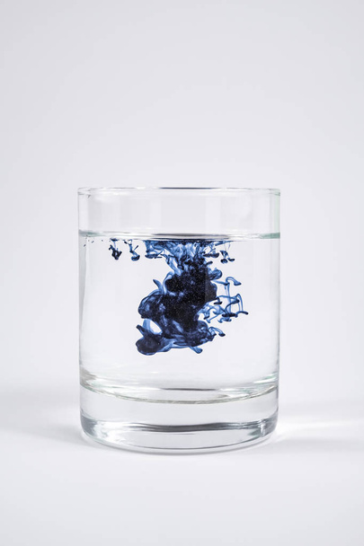 Water contamination concept. Dark substance dissolving with clea - Фото, изображение