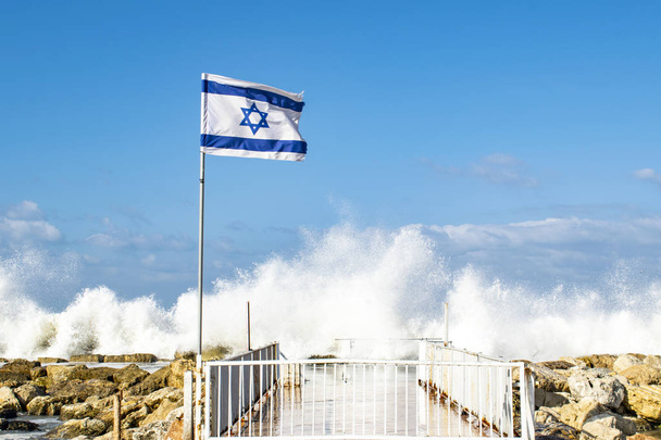 Flaga Izraela przy promenadzie w Tel Awiwie, flaga wśród fal Morza Śródziemnego, Dzień Niepodległości - Zdjęcie, obraz