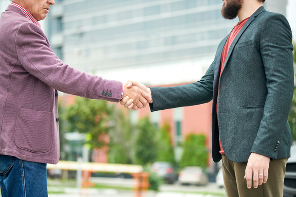 Mid section side view portrait of successful senior businessman shaking hands with partner outdoors, copy space - Photo, Image