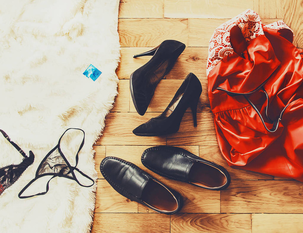 scattered clothes and lovers shoes. Night of love. Selective focus - Photo, Image