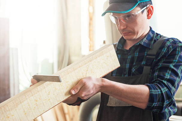 İşçi ölçümleri bir ahşap tahta yapar - Fotoğraf, Görsel