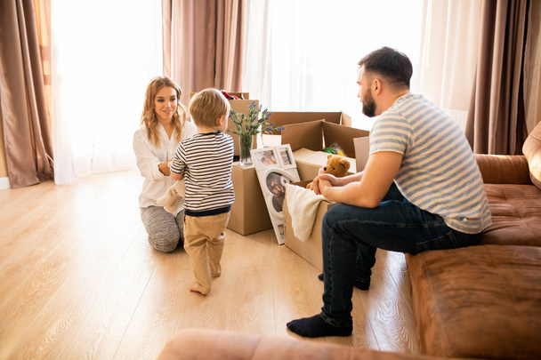 Täyspitkä muotokuva onnellinen perhe leikkii lapsen kanssa kotona nauttia viikonlopun yhdessä
 - Valokuva, kuva
