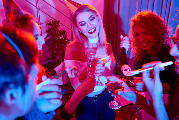 Wesoły fantazyjne kobiety i mężczyźni mający przyjęcie z szampanem obchodzi nowy rok razem - Zdjęcie, obraz