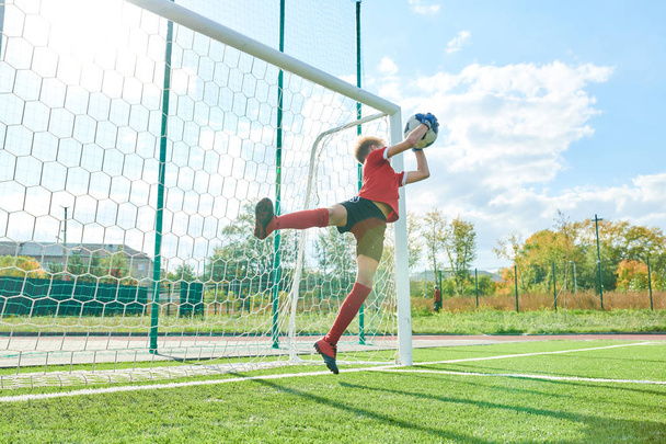 Ganztägiges Porträt eines Teenagers, der sein Tor während eines Fußballspiels im Freien verteidigt, Kopierraum - Foto, Bild