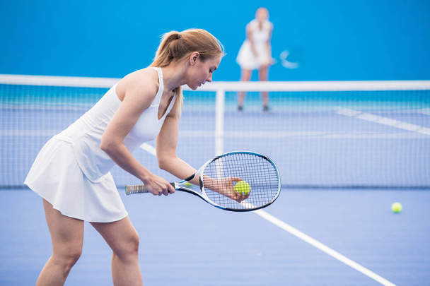 Портрет молодої спортсменки, готової подавати м'яч під час гри в теніс у дворі, копіювати простір
 - Фото, зображення