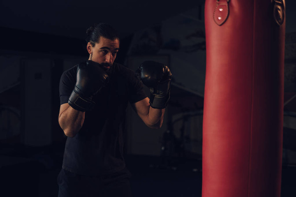 Boxer in guard in front of the heavy bag - Photo, Image
