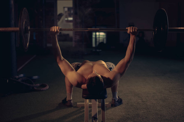 Homme torse nu faisant banc de presse dans la salle de gym
 - Photo, image