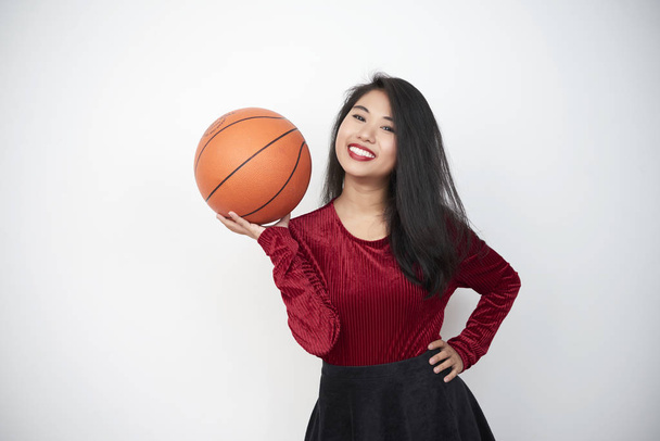 Ázsiai gyönyörű nő gazdaság labda a kosárlabda játék, és mosolyogva fehér háttere előtt portréja - Fotó, kép