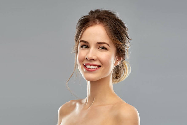 smiling young woman over grey background - Φωτογραφία, εικόνα