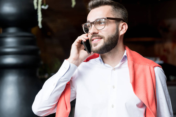 Портрет красивого молодого бізнесмена, який розмовляє по телефону і посміхається, дивлячись, копіює простір
 - Фото, зображення