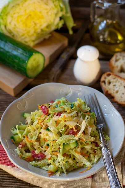 Fresh salad of napa cabbage with carrots, cucumber and salami - Photo, Image