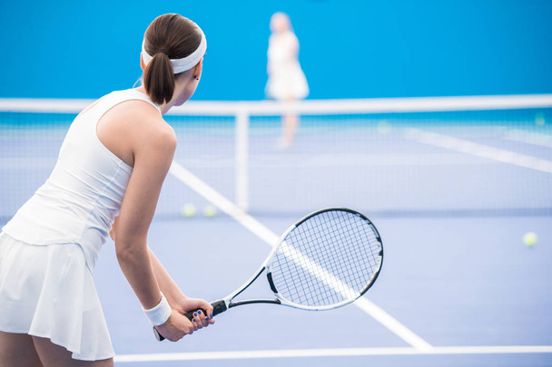 Rückansicht einer Tennisspielerin mit Schläger während eines Matches vor Gericht, Kopierraum - Foto, Bild